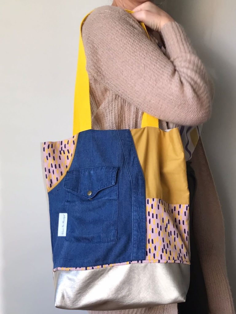 mozaïektas van restjes stof, met bruikbaar zakje op de voorkant met drukknop, binnenzakje met ritssluiting en verstevigde bodem